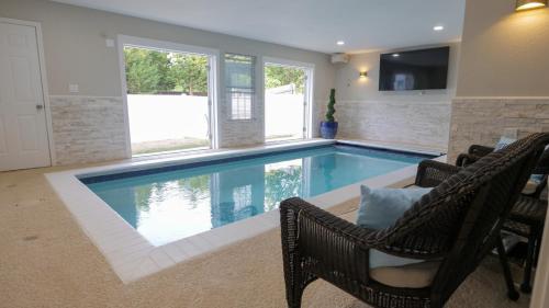 a swimming pool in a living room with chairs at Oasis - Indoor Swimming Pool in The Colony