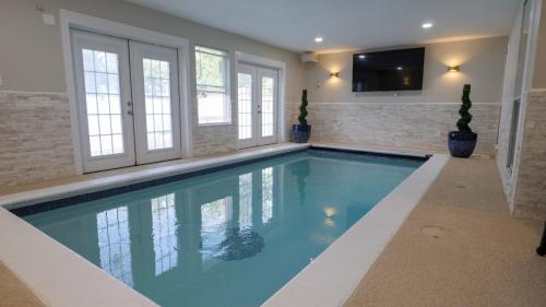 a large swimming pool in a home with a tv at Oasis - Indoor Swimming Pool in The Colony