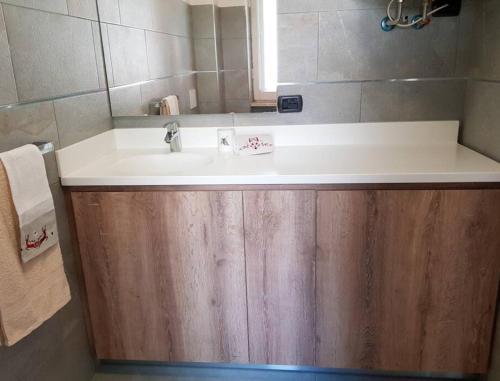 a bathroom with a white sink and a mirror at Appartamento in Champoluc- Centro in Champoluc
