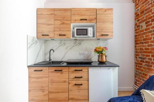 a kitchen with a sink and a microwave at Gdańska 44 Apart in Łódź