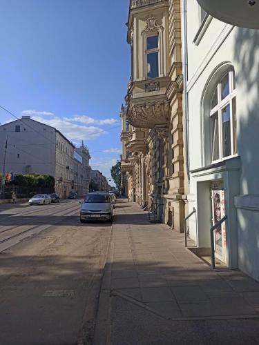 a car parked on a street next to a building at Gdańska 44 Apart in Łódź