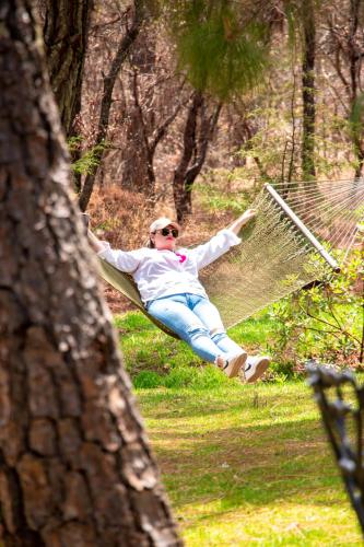 a woman sitting in a hammock in a park at Luahara Glamping Tapalpa - Domo Natural Experience in Tapalpa