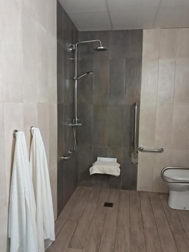 a bathroom with a shower and a toilet and towels at CabraBerry in Cabra de Mora