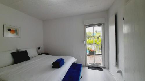 a white bedroom with a bed and a window at Blue Lagoon in Nehren