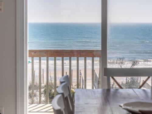 a room with a view of the beach from a window at LegaSea in North Topsail Beach