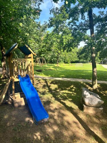 a playground with a blue slide in a park at Къща за гости Геша Вю in Dryanovo