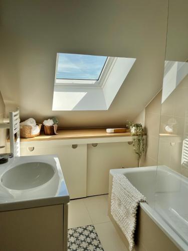 a bathroom with a sink and a tub and a window at Appartement Zola in Troyes