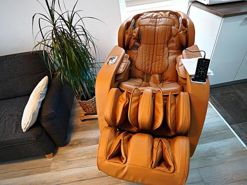 布拉索夫Relaxing Coresi Studio的沙发旁边有一张棕色皮革躺椅