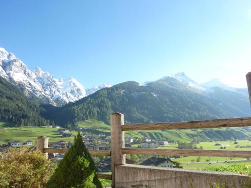 a wooden fence with mountains in the background at Ferienhaus Stubaiblick in Neustift im Stubaital