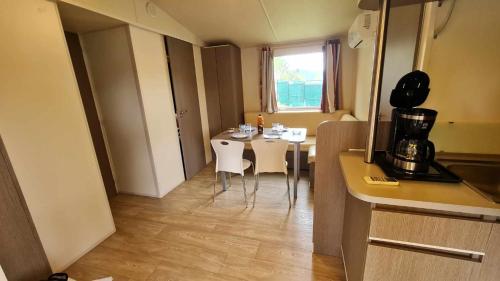卡代纳Mobil Home au calme Camping 4 Cadenet的房间里有一张桌子和几把椅子的厨房