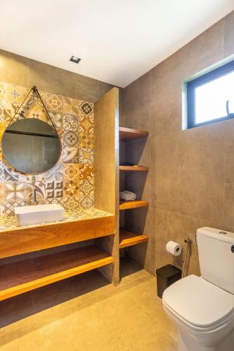 a bathroom with a toilet and a mirror at Lobo Gris - Recanto idílico com vista espetacular in Itatiaia