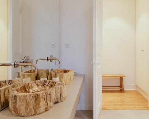 a bathroom with three wooden sinks on a counter at A Casa Brava in Santarém
