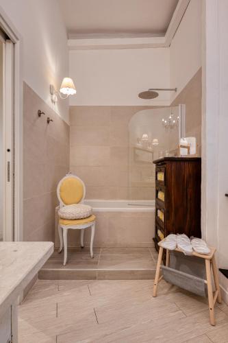a bathroom with a tub and a chair and a shower at Your House Rooms in Genova