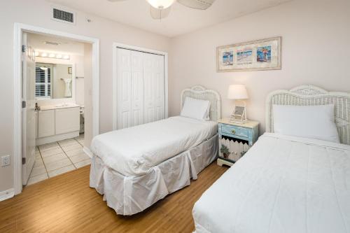 Un dormitorio con dos camas y un espejo. en Island Princess 501 - Shoreline Shindig, en Fort Walton Beach