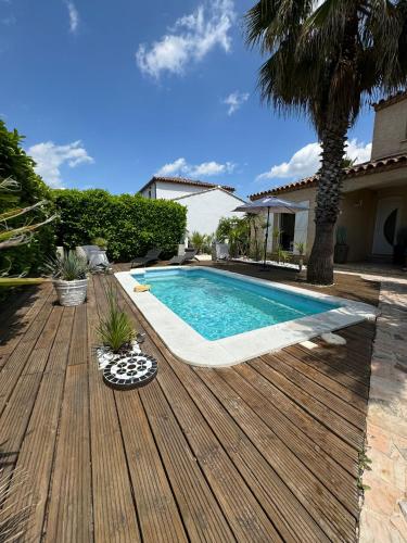 - une piscine sur une terrasse en bois à côté d'une maison dans l'établissement Villa Piscine et Jardin Ensoleillé, à Saint-André-de-Sangonis