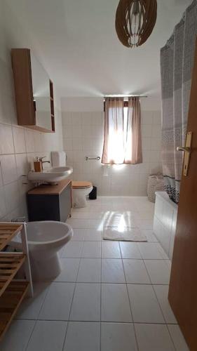 a white bathroom with a sink and a toilet at Apartman Lila in Poreč