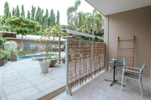 a patio with a fence and a table and chairs at Tamarindo Bay Boutique Hotel, Apartments & Suites in Tamarindo