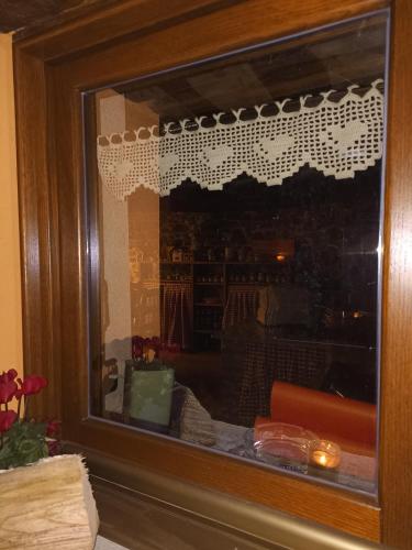 a window with a reflection of a room at Baita Eleonora in Argegno