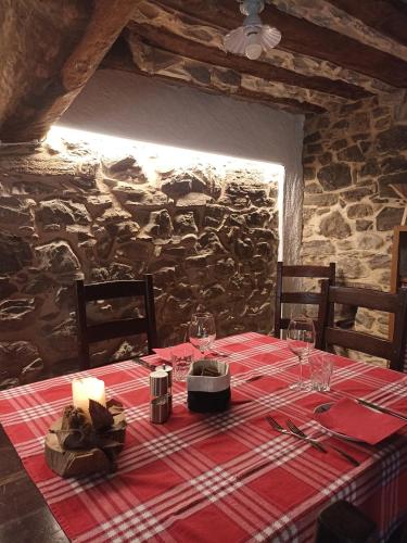 a table with a red table cloth and a candle on it at Baita Eleonora in Argegno