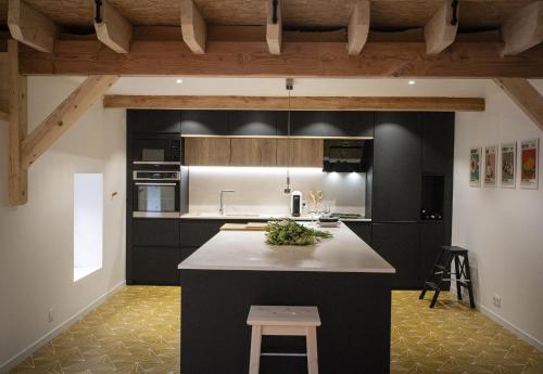 une cuisine avec des armoires noires et un comptoir blanc dans l'établissement Venez Chez Vous Mountain View, à Montmin