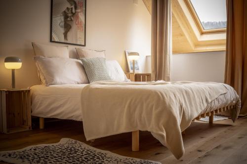 une chambre avec un lit avec des draps blancs et une fenêtre dans l'établissement Venez Chez Vous Mountain View, à Montmin