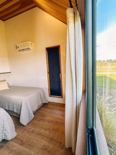 a room with two beds and a window at Cabanas Purunã in Balsa Nova
