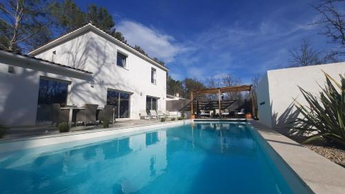 une piscine devant une maison blanche dans l'établissement Gardincour, à Fayence