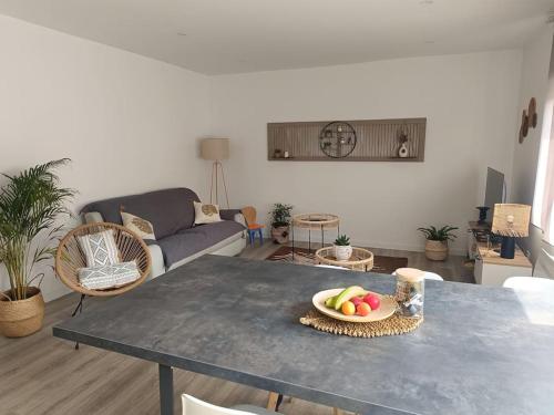a living room with a table with a bowl of fruit on it at L'appart' Centre ville 3 chambres in Rethel