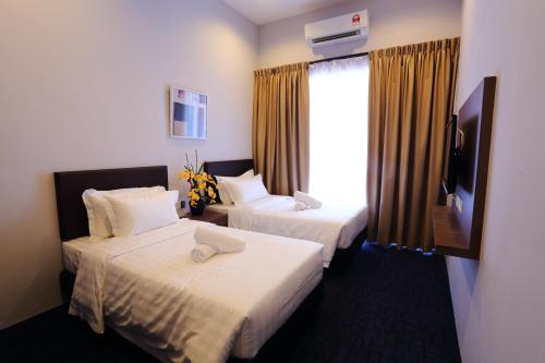 a hotel room with two beds and a television at S Boutique Hotel in Ipoh
