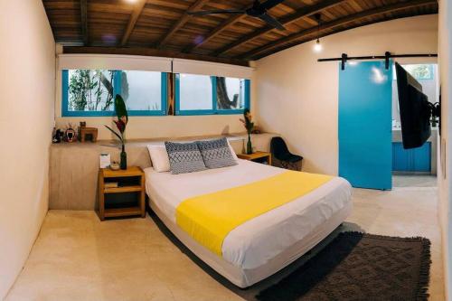 a bedroom with a large bed in a room with windows at Casa Cocos Bungalow en Playa La Ropa Zihua con AC in Zihuatanejo
