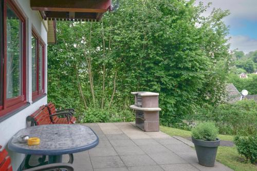un patio con tavolo, sedie e mangiatoia per uccelli. di FH "Schmetterling" am See im hessischen Bergland a Kirchheim