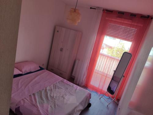 une petite chambre avec un lit et une fenêtre dans l'établissement Logement entier - appartement, à Bordeaux