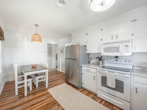 a kitchen with stainless steel appliances and a table at Little Bird in Surf City