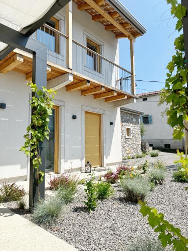 a house with a yellow door and gravel yard at Casa Matko in Kostanjevica na Krasu