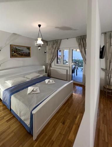 a bedroom with a large bed and a balcony at Viola Istra Guest House in Štinjan