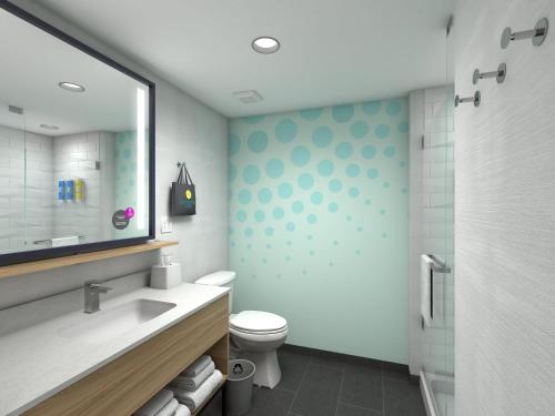 ein Badezimmer mit einem WC, einem Waschbecken und einem Spiegel in der Unterkunft Tru By Hilton Wisconsin Dells in Wisconsin Dells