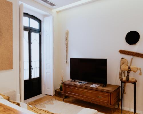 a living room with a flat screen tv on a table at A Casa Brava in Santarém