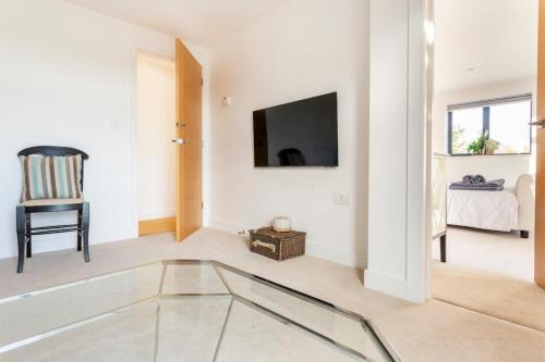 a living room with a glass table and a tv at The Retreat, Sauna & Hot Tub, Charming & Cosy Gem in Blandford Forum