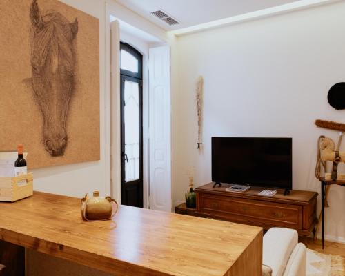 a living room with a table and a television at A Casa Brava in Santarém