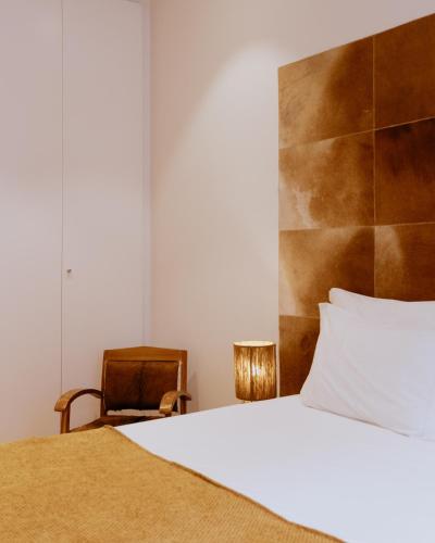 a bedroom with a bed and a chair at A Casa Brava in Santarém