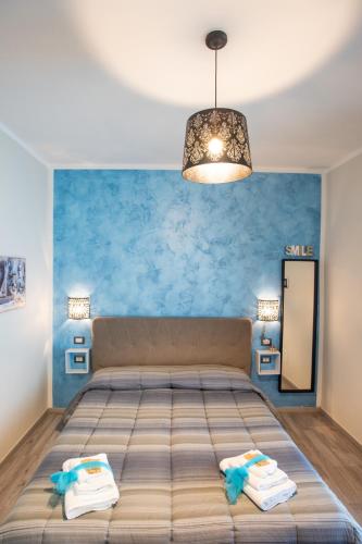 a bedroom with a bed and a blue wall at B&B Dionea in Santa Maria di Castellabate