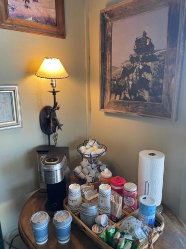 a table with cups and dishes on it with a lamp at Rawlins Western Lodge in Rawlins