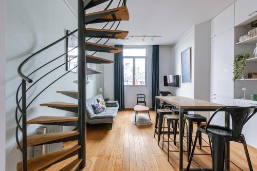 a spiral staircase in a living room with a table and chairs at New Stylish Grand place City Center Duplex in Brussels