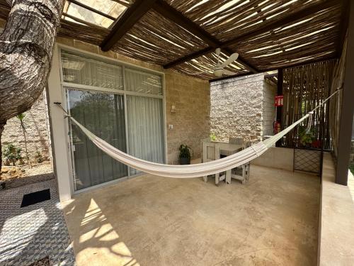 a hammock on a porch of a house at Hotel Casa de Campo Conkal Merida in Conkal