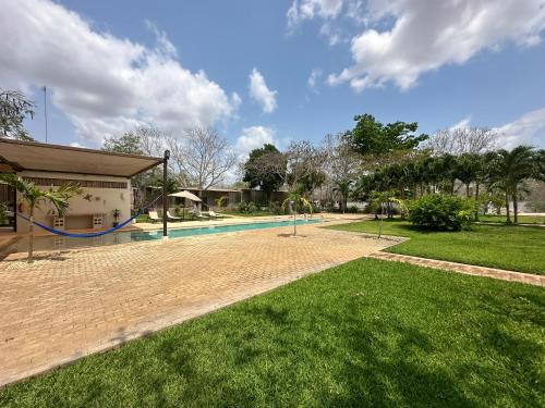 a swimming pool in a yard next to a house at Hotel Casa de Campo Conkal Merida in Conkal