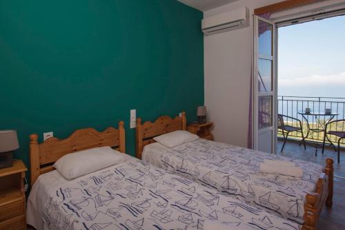 a bedroom with two beds and a green wall at Elena Studios in Athanion