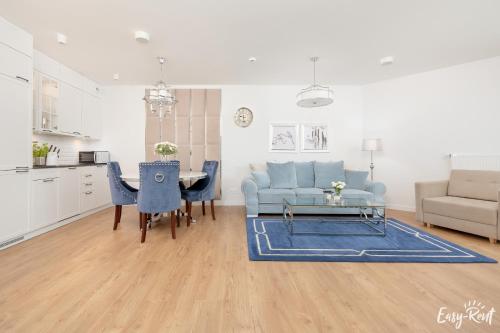 a living room with a blue couch and a table at Pinea 204 - Easy-Rent Apartments in Pobierowo