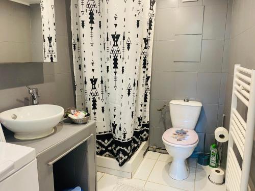une salle de bain avec toilettes et rideau de douche dans l'établissement Studio Saint Denis, à Lagny-sur-Marne