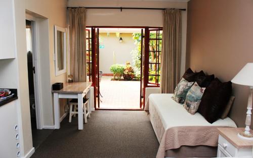 Zimmer mit einem Bett und einer Tür zum Hof in der Unterkunft Bayside Guesthouse in Port Elizabeth