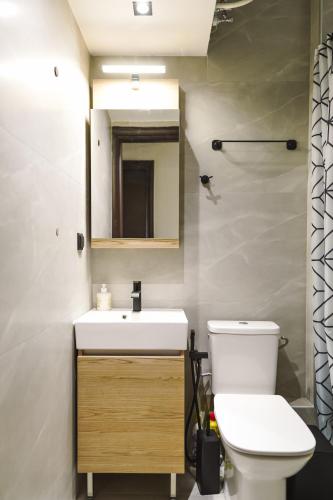 a bathroom with a toilet and a sink and a mirror at Olive Garden by Golden Host in Nea Moudania